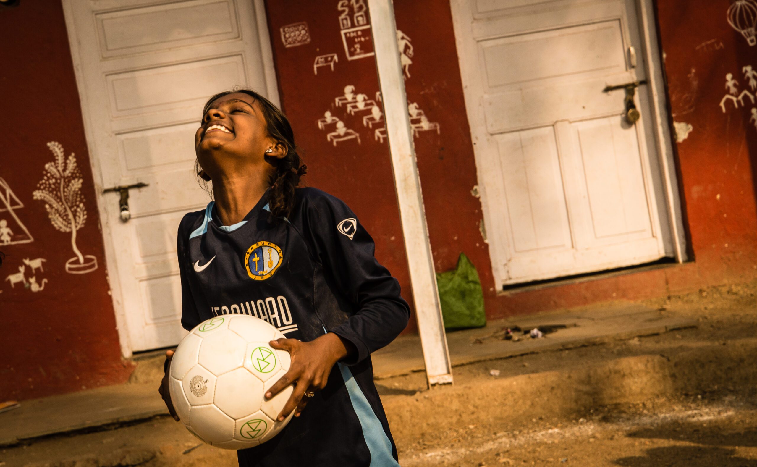 girl holding ball and smiling