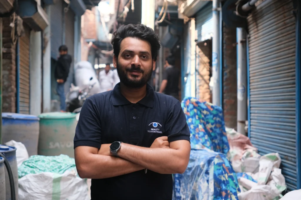 A man wearing a black shirt featuring the 'Reality Tour and Travels' logo, working as a tour guide.
