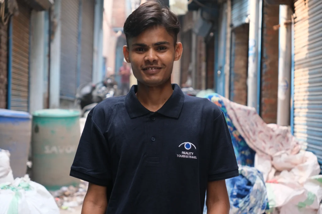 A man wearing a black shirt featuring the 'Reality Tour and Travels' logo, working as a tour guide.