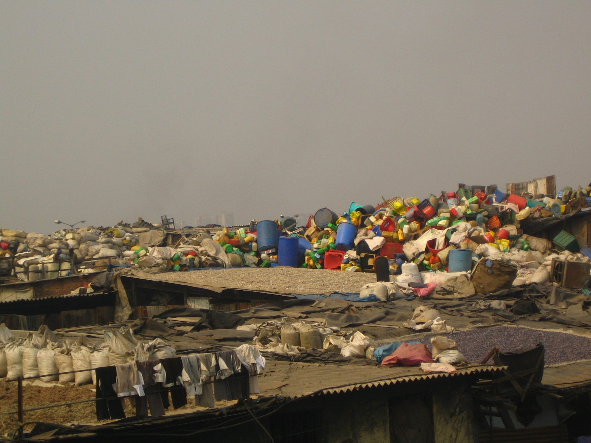 Dharavi Slum Aerial view rooftop containing garbage and plastic cans.