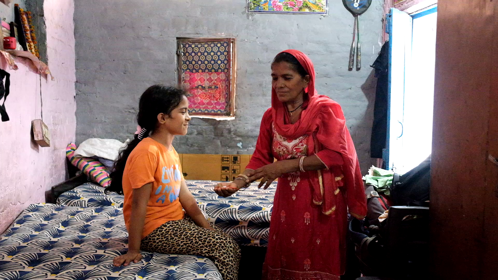 An elderly grandmother lovingly performs the traditional salt and mustard ritual around her grandchild. This age-old practice is believed to protect children from the effects of the evil eye and negative energies.
