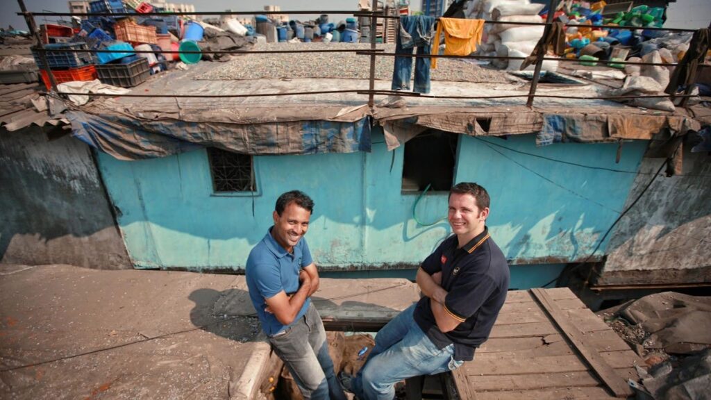 Reality tours founders Krishna and Chris sitting on a rooftop at Dharavi used on our blog on slums, social change and the story of Reality tours and travel.