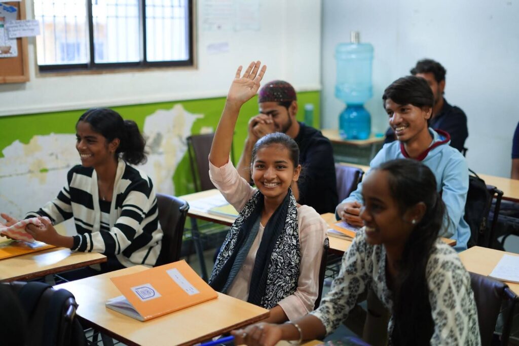 Local students participating in an educational program supported by Reality Tours & Travel (known as reality gives), showcasing our commitment to community development in Mumbai