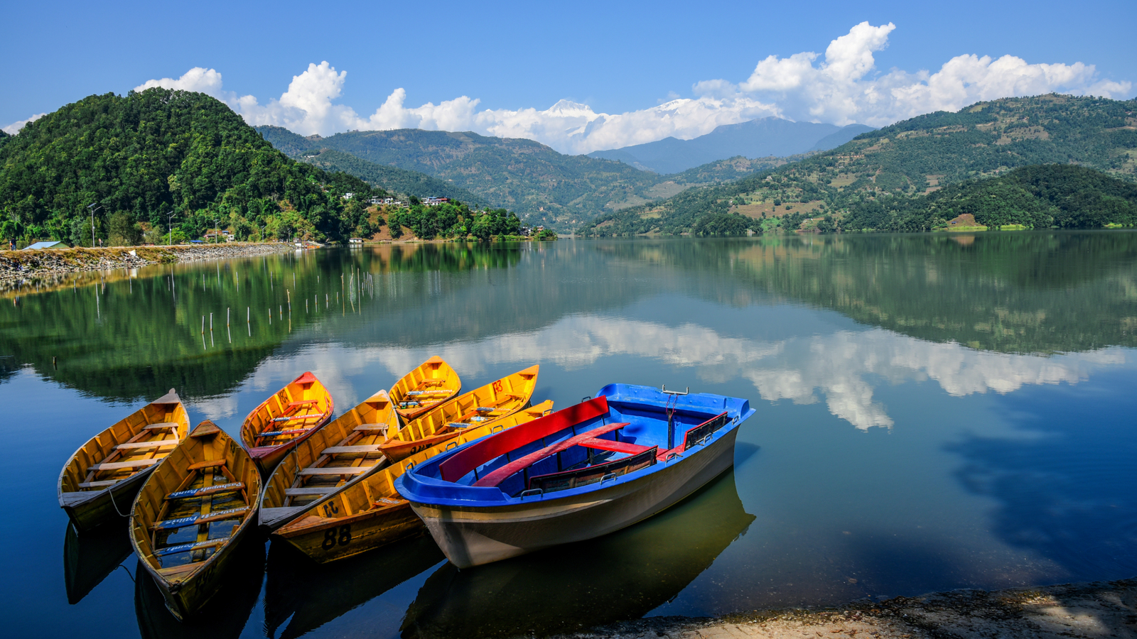 Phewa Lake in Pokhara, Nepal, reflecting the Annapurna mountains and Machhapuchhre peak.