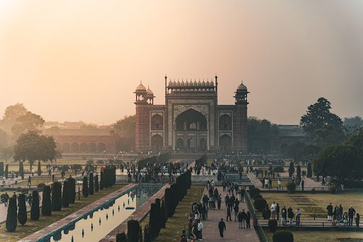 Visitors walking through the Mughal gateway at the Taj Mahal complex in Agra, a must-see cultural highlight of the Golden Triangle tour in India.