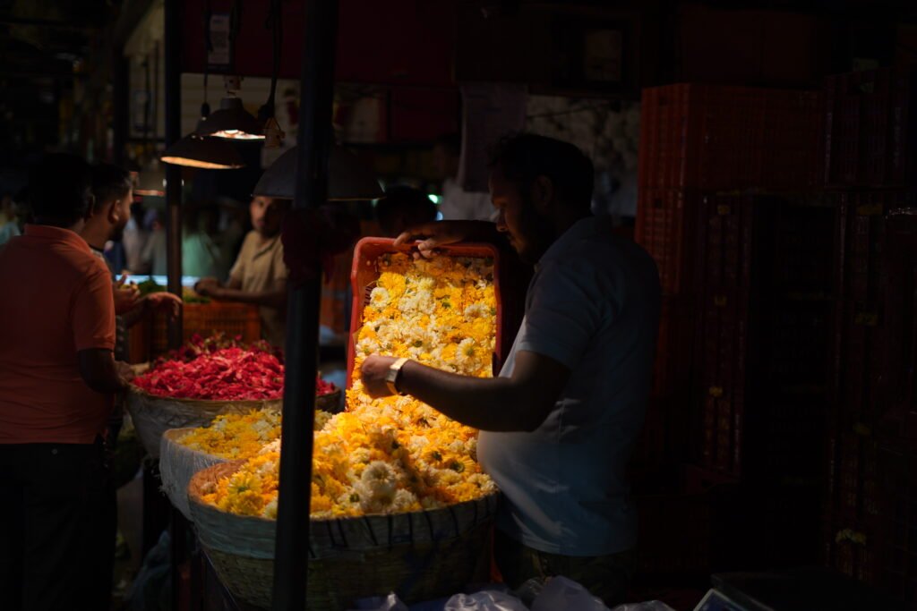 Nighttime hustle at Mumbai's Dadar Flower Market: vendors tending to massive piles of colorful marigolds and roses