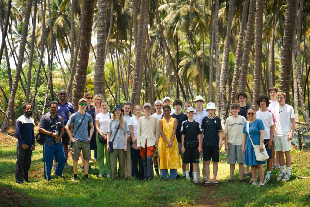 A diverse group of international tourists standing together on a guided outdoor walking tour in India.