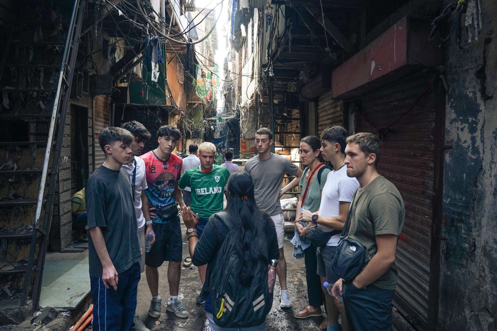 A student group listening to a Reality Tour guide during an immersive community learning walk on a School & College Tour